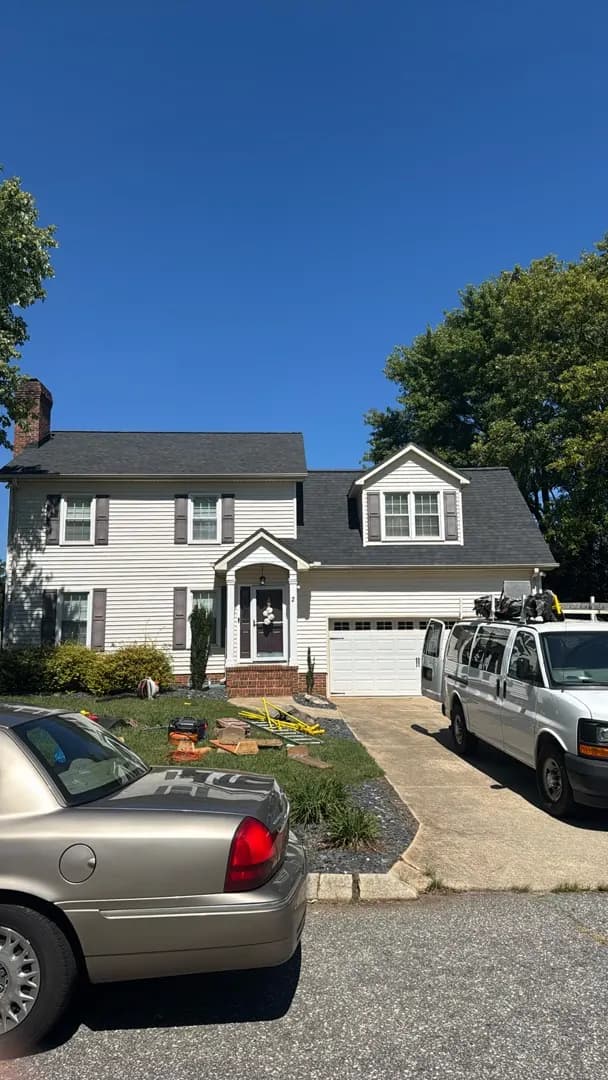 Completed shingle roof on a white two-story home