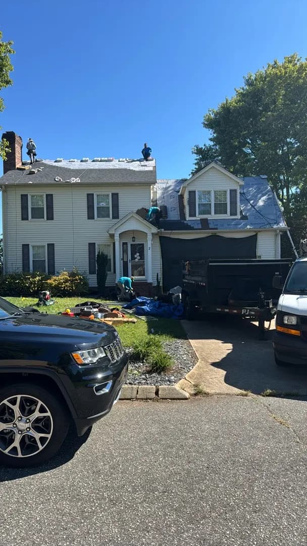 Roof installation underway on a white two-story home