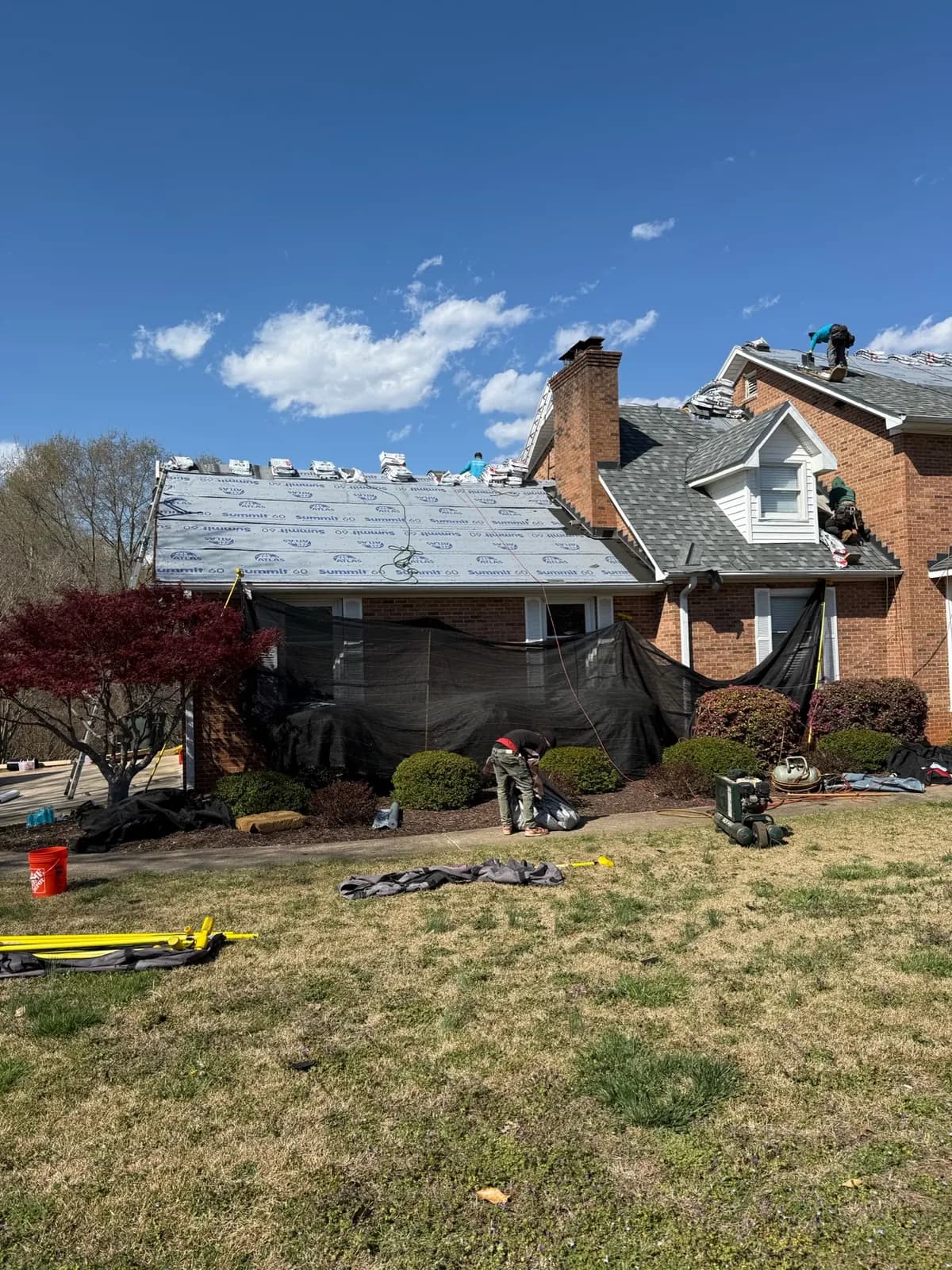 Roof replacement underway on a stone home