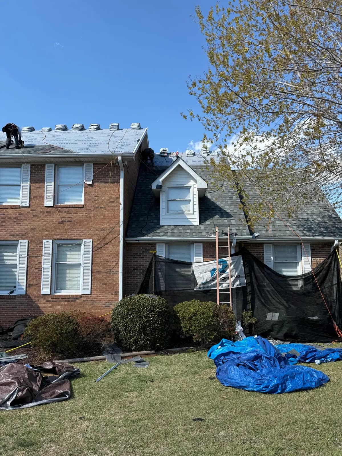 Residential roof project with protective tarps in place